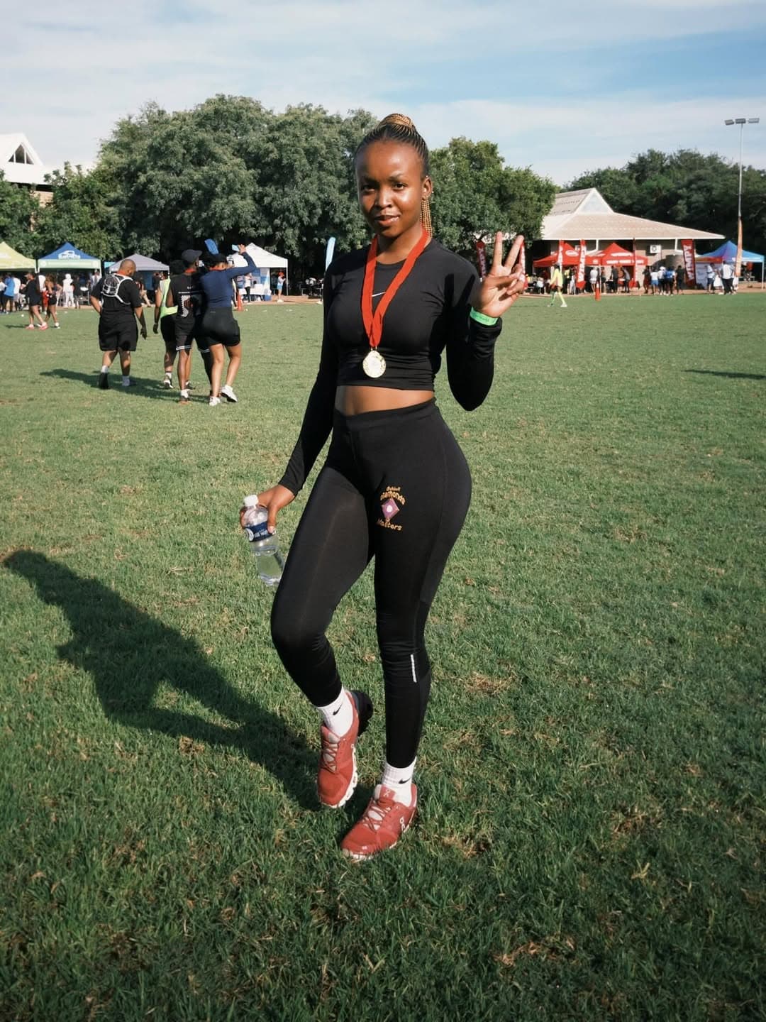 Runner posing with a medal after finishing a race